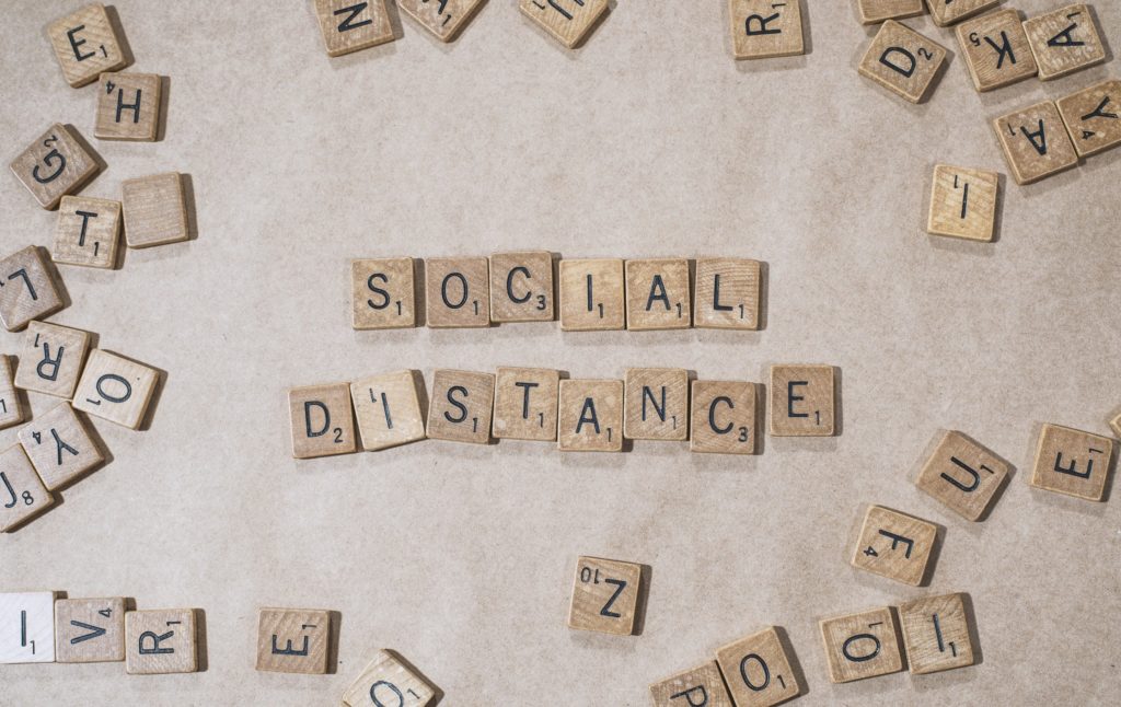 Le mot SOCIAL DISTANCE écrit avec des lettres de scrable